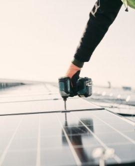 Main fixant un panneau photovoltaïque